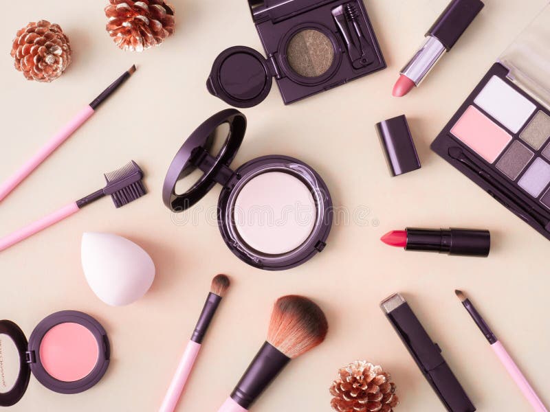 Makeup products including lipsticks, brushes, and compact powder on a light background